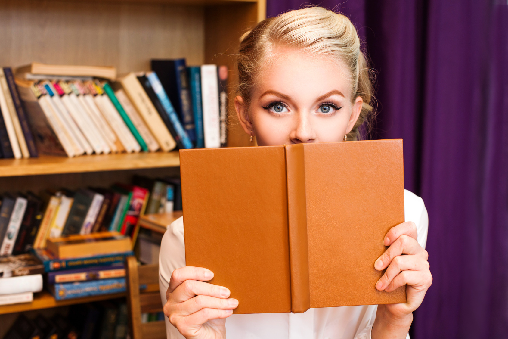 Young beautiful blonde student girl with book