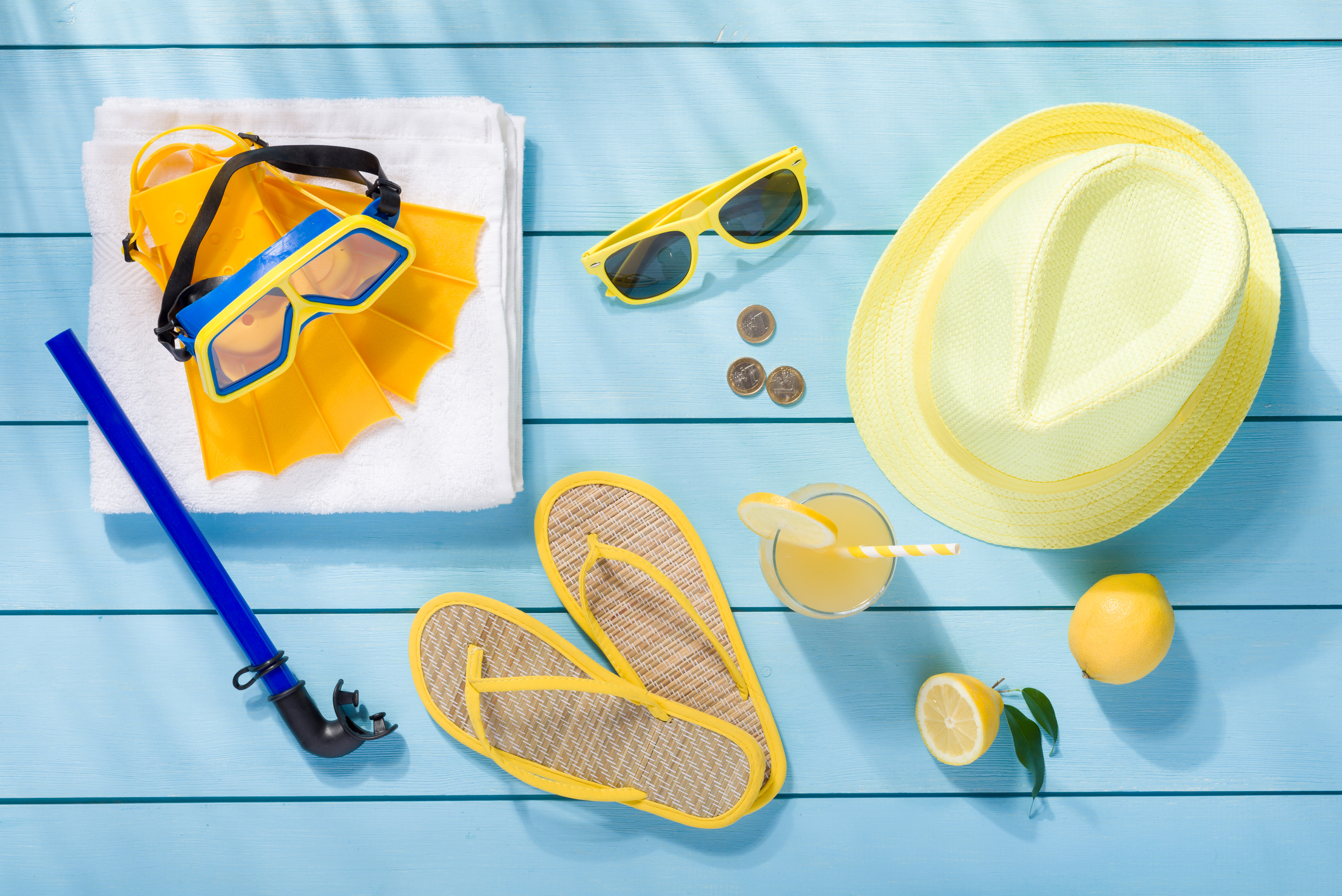 Summer accessories on blue wooden background top view