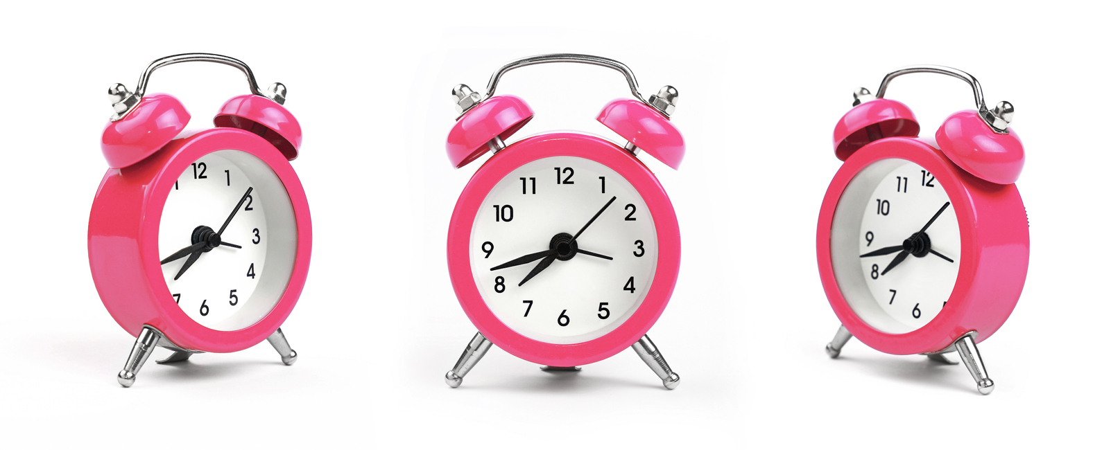 Three pink alarm clock over white