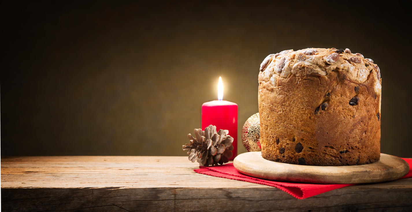 Very simple Christmas, panettone and lit red candle. Space for text.